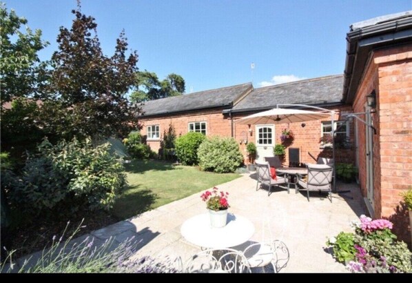 Full enclosed garden with hot tub & barbecue. Dining table & chairs & loungers