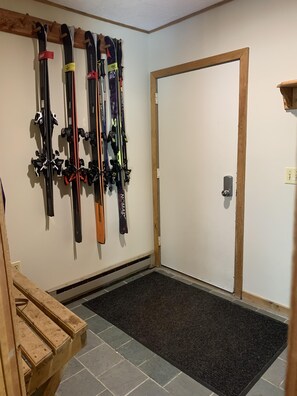 Entry mudroom with benches, coat hooks, and ski racks.