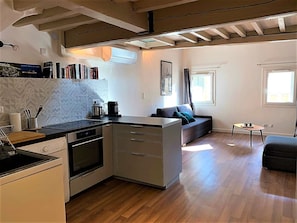 The fully equipped kitchen open on the living-room