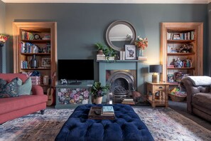 Cosy Living Room with comfortable seating, smart TV with Sky, PlayStation, games, toys and books