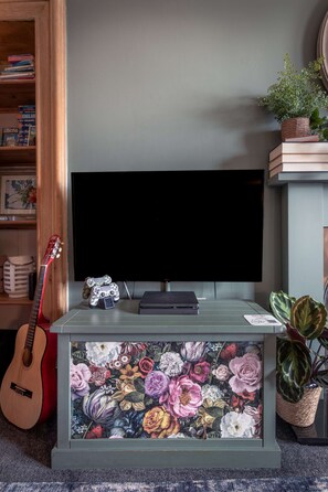 Cosy Living Room with comfortable seating, smart TV with Sky, PlayStation, games, toys and books
