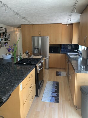 KItchen with refrigerator, microwave, stove with air fryer, and dish washer