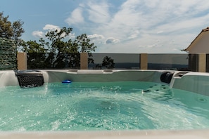 An outdoor terrace with a hot tub