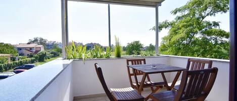 Der Balkon mit Tisch und Stühlen mit Blick auf den Park und die Straße