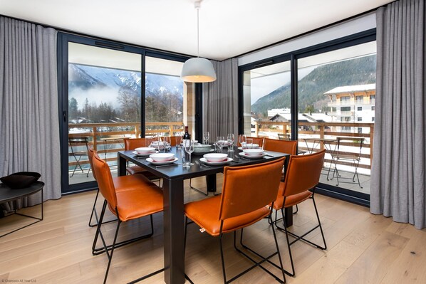 Floor to ceiling windows with dining table seating 8