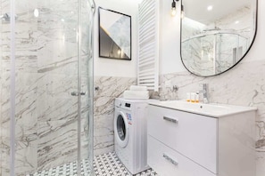 Bathroom with washing machine and towels.
