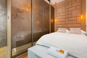 A bedroom with a double bed adorned with soft lighting and neutral tones, creating a relaxing ambiance.