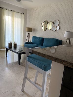 Living area with sofa bed, kitchenette and wall mounted flat screen television
