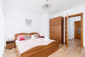 A cozy bedroom with a double bed, bedside tables, and wooden furniture complementing the warm atmosphere.