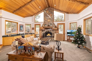 Grand Living room with a smart t.v. and a wood-burning fireplace. Bar area with Keurig and a mini wine fridge.