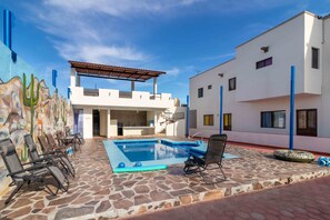 Heated swimming pool, lounge chairs in back yard; outdoor kitchen & gym.