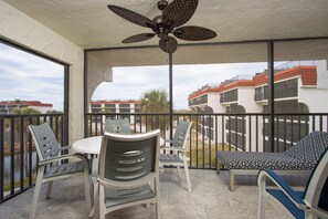 Screened lanai with outdoor dining table and sun lounger