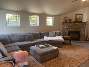 Family Room. Large sectional. Vaulted ceiling. River rock fireplace. 65" Roku TV