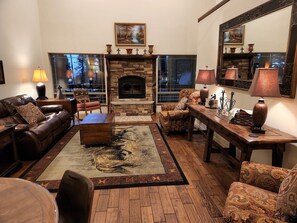 Livingroom, with comfortable leather sofa, game table, area rugs.