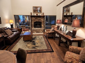 Livingroom, with comfortable leather sofa, game table, area rugs.