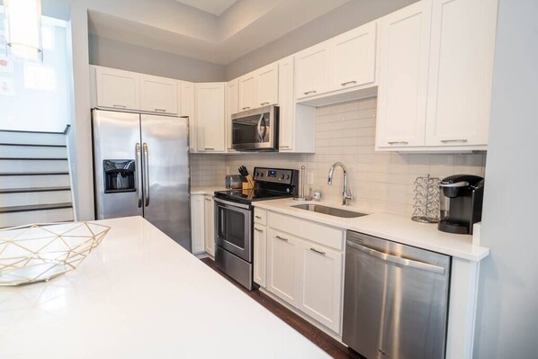 Our bright and white kitchen! You can see here the stairs that lead to our landing with our front balcony.