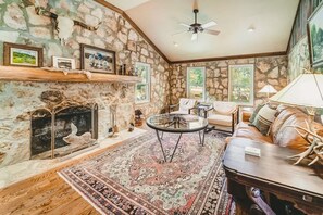 The Ranger main living and dining spaces with original rock walls and stone fireplace. This was the main lodge for the Girl Scout Camp with many songs sung and skits performed in this gathering space.