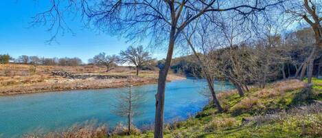 Camp Blanco has manicured, park like land on the lower level of the property along the Blanco River.