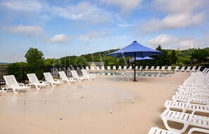 Clubhouse pool with lounge chairs and splash pad for kids