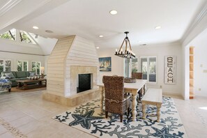 Coastal charm meets cozy comfort in this open-concept dining and living area