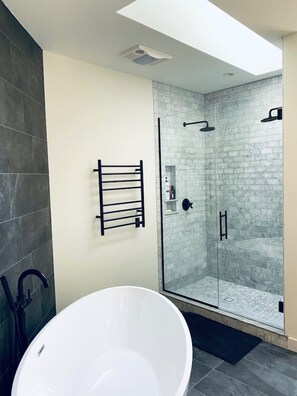 Marble-lined double shower, heated towel rack, and deep soaking tub. 