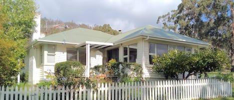 Classic country cottage surrounded by a pretty garden in a rural landscape.