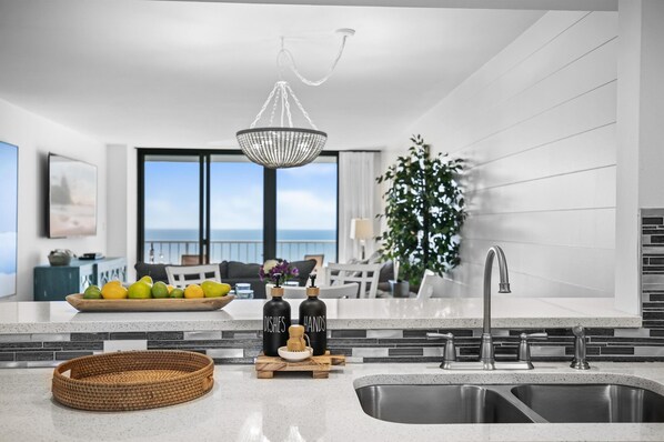 Kitchen open to counter seating, dining and living room, all with ocean views
