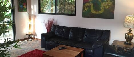 Comfortable Italian leather sofa, love seat, art and sliding glass doors.