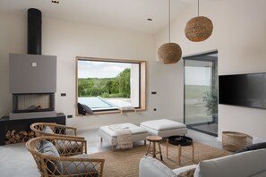 Geräumiges Wohnzimmer mit Blick auf den modernen Infinity-Pool
