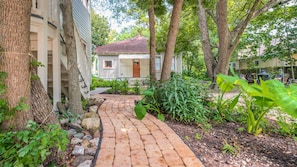 Cobblestone walkway to the building among the beautiful trees and flowers.