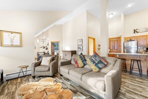 Living area with a flat-screen TV, sleeper sofas, and ample seating to cozy up around the fireplace.