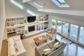 Spacious Living Room with vaulted ceilings and floor to ceiling windows