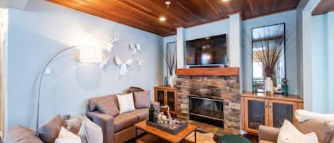 Cozy living space. Instant gas fire, smart TV and large kids games area set to the side. Beautiful views into the woods.