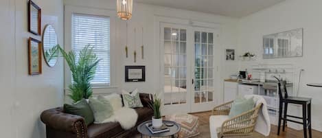 view from the front door looking into the living area and bed behind the glass french doors