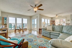 Stunning beach and ocean views greet you through glass sliding doors in the kitchen and living room. Relax on the comfy sectional or step out to the balcony for the perfect cup of morning coffee!  #SeasideSerenity