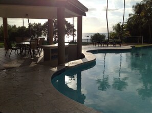 Pool has several seating areas and it is next to the beach.
