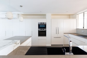 Sophisticated open plan Bosch kitchen with chic stone benchtops