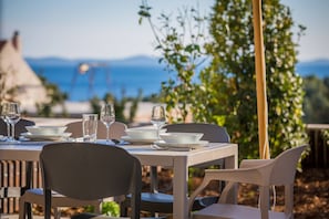 A dining table with chairs has been set up on the outdoor terrace of Croatia luxury villa Elegance for vacation and rent