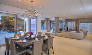 The interior of the Croatia luxury villa My Dream on Brač with a dining table and chairs, a living room and an exit to the outdoor terrace
