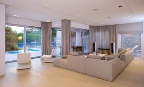 The living room of the Croatia luxury villa My Dream with a sofa, armchairs, a wooden table and direct access to the outdoor terrace in Sumartin on Brač