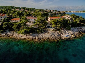 A view of a luxurious holiday villa surrounded by a dense pine forest on Brač