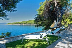 Sea view from sunbeds in the courtyard of the modern newly built Croatian villa with pool in Sumartin