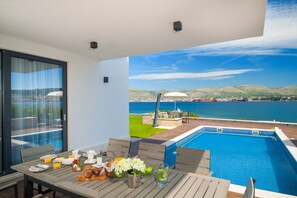 Breakfast on the outdoor dining table on the covered part of the terrace of a Croatia luxury villa Trogir 1 with parking and spa 
