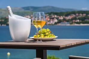 Fruit and champagne  on a small table on the private terrace of a Croatia luxury modern villa with pool on Ciovo