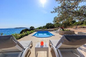 Deck chairs by the private pool of the beachfront villa in Ciovo with parking and wi-fi