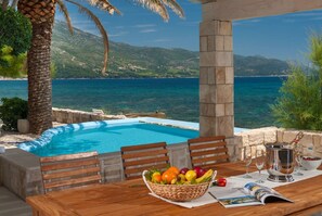 Outdoor dining area of Croatia luxury beachfront Villa Gracia Grande in Orebić with private pool and sea view for vacation and rent.
