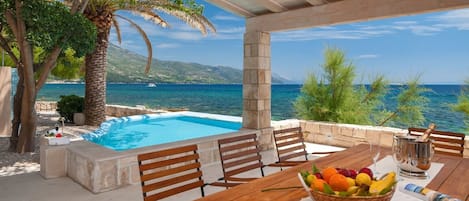 Outdoor dining area of Croatian luxury beachfront Villa Gracia Grande in Orebić with private pool and sea view for vacation and rent.