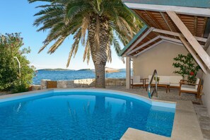 Mediterranes Dalmatien Luxusvilla Mare in Orebić am Strand für Urlaub und Miete mit privatem Pool und schöner Liegewiese mit Holzliegestühlen.