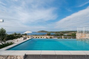 Private outdoor pool in front of the pet-friendly Trogir luxury villa Sea Side Drvenik with private pool for family vacations and rent