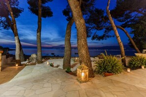 Mediterranean terrace with trees in the traditional stone house right at the beach on Brac